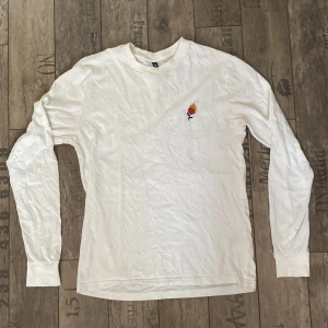 Vit långärmad t-shirt - Vit långärmad t-shirt med ett litet broderi på vänster sida.