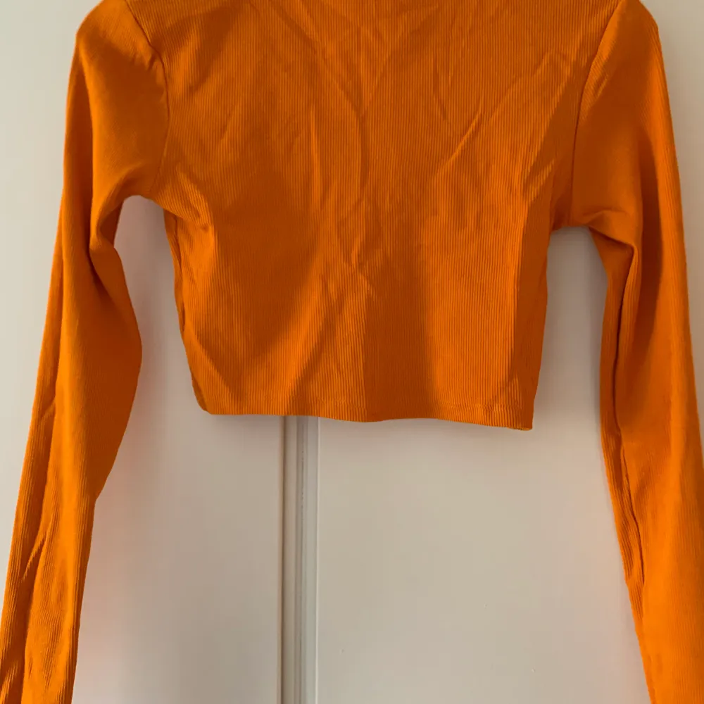 Orange långärmad crop top från Zara i orange. Endast använd en gång, i nyskick! Passar perfekt nu i höst eller till Welma kostymen.. Toppar.