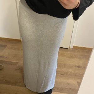 Grå långkjol - Säljer denna gråa långkjolen från HM i storlek L👌🏼köpt second hand men aldrig använt den själv, superbra skick!! Bra längd, går ända till fötterna🙌🏼 har två slitsar
