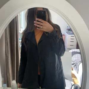 Trenchcoat  - En marinblå halvlång trenchcoat från Calvin Klein. Har inte använt den så ser ut som nyskick.