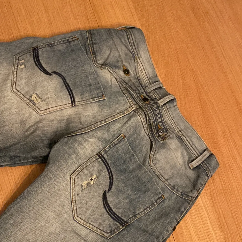 Ett charmigt par jeans med perfekt distressed design och wash.  Vid baksidan finns även tre knappt med en rem som går att justera midjan, perfekt för dig som ogillar bälten och annars en snygg detalj. 30W/32L Jag möts gärna upp Stockholm centralt :)  . Jeans & Byxor.