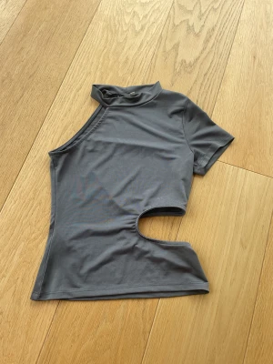 Topp med cut-out - Jättesnygg grå topp med cut-out i midjan. Från Nelly 