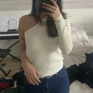 Ribbstickad One-shoulder topp - Jättefin vit ribbstickad One-shoulder topp. Gott skick💗🤍köpt från nelly 