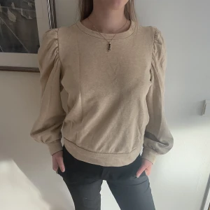 Tröja med puffärm - En beige tröja, knappt använd. Passar jättebra till kostymbyxor eller en söt kjol! 