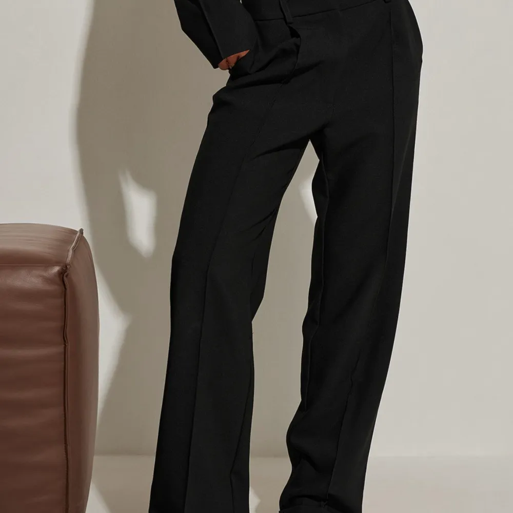 Ett par svarta kostymbyxor från Hanna Schönbergs kollektion med Nakd. De är i storlek 34 men sitter som en 36 och midjan är medelhög. . Jeans & Byxor.
