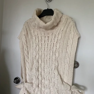 Stickad väst - Fin stickad beige bäst från moss copenhagen, jättefin att ha över annan tröja. Har polo och knyte på sidorna