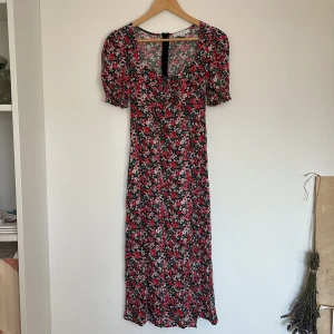 Klänning - Blommig klänning med slits.