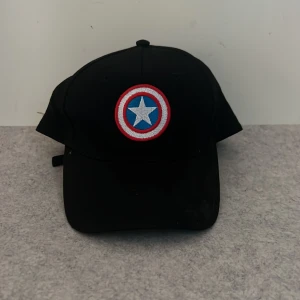 Captain America’s Shield Logo Keps  - Unisex snapback keps för den som gillar Marvel. 