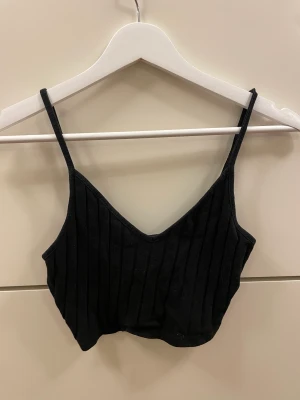 Croppat linne - Svart ribbat croppat linne ifrån shein. Jättebra skick! Justerbara band. 