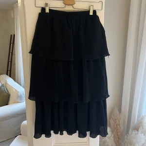 Glittrig Volangkjol - Svart volangkjol med glitter. Andra bilden visar glittret på kjolen. 🪩