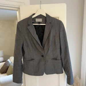 Grå kavaj  - En kortare mörkgrå kavaj från HM. Ger en figursydd känsla på kroppen och är superfin. 