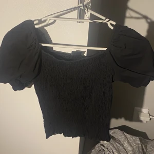Topp - En tajt stretchig kort topp som har puffärmar. 