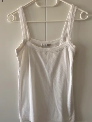 Vit linne - Bomull, det finns en prick på baksidan men man kan inte se den alls när man ha på sig den