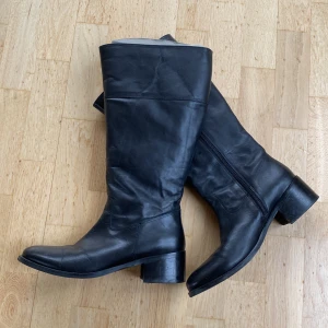 Läderstövlar Wildflower storlek 39 - Knappt använda stövlar i svart läder. Dragkedja. Storlek 39, benstorlek L. Märke Wildflower. Nagg i klacken (se närbild 2).