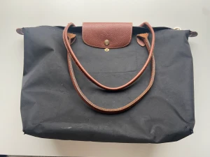 Longchamp väska - Säljer denna fina Longchampväska. Den har en del defekter och hål (därav priset) men i helhet är den jättefin💕