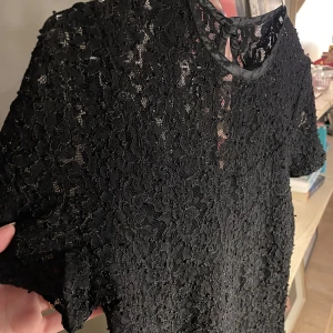 Svart klänning  - Okänt märke svart klänning i kortare modell   Bra skick, lätt skimmrig 