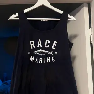 Ett marinblått linne ifrån Race Marine i storlek 40. Linnet är i använt skick och finns några fläckar men annars är det i bra skick. 100% bomull