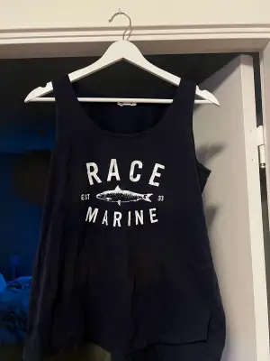 Ett marinblått linne ifrån Race Marine i storlek 40. Linnet är i använt skick och finns några fläckar men annars är det i bra skick. 100% bomull