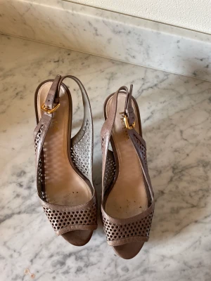 Beige/gråa PRADA plateauskor.  - Bekväma med mjukt fint läder. Endast använda några gånger. Mycket fint skick förutom något jack i lädret på klackens nedre del.  