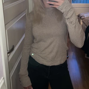 Tröja Chiquelle - Beige tröja med silvriga detaljer längst ner på ärmarna. Storleken var onesize men jag skulle säga att den passar s/xs.