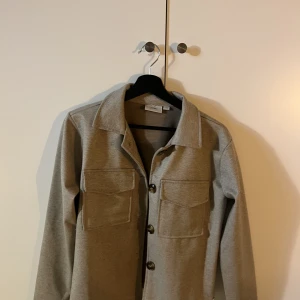 Kort kappa  - Fin kort kappa i färgen Begie, använd 2 gånger. Storleken är Xs. 