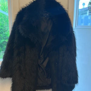 Svart päls jacka  - Det är en fejk päls Jack bra kvalitet. Tål vatten och sne passar till allt. 
