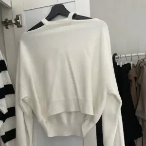 Tjock vit tröja med ”cuts” vid axlarna och ballongärmar. Den har stått i garderoben ett tag därför är den skrynklig. Använd fåtal gånger. 