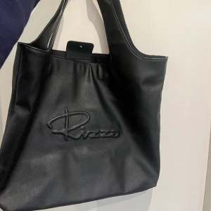 Väska - Säljer denna väskan ifrån RIZZO då den inte kommer till användning längre. Knappt använd, så i väldigt gott skick. En skitbra väska som rymmer extremt mycket. Perfekt om man ska iväg eller till skolan. Riktig pärla till väska! Köptes för 599 kr 
