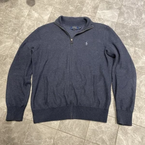 Ralph Lauren Fullzip  - Riktigt fin Ralph lauren halfzip i materialet prima cotton. Den har en mörkblåare färg och den är i storleken S. Den är även i väldigt fint skick. Kontakta gärna vid frågor!
