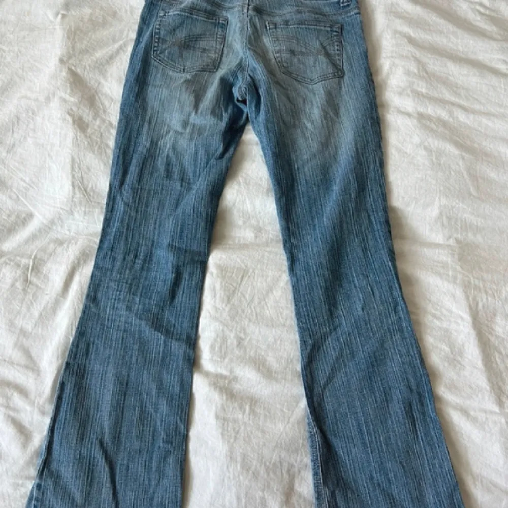 Utsvängda blåa jeans, lågmidjade💕 41 cm i höfter och 77 cm i innerbenet☺️ De är i ett mycket bra sick. de var lite kortare än vad jag hade önskat, det är derför jag säljer dem❤️Bilden är dålig för byxorna är randiga i motivet!. Jeans & Byxor.