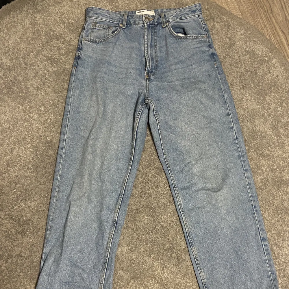 blåa baggy jeans från bershka i storlek 38. använda fåtal gånger. modellen är lite mer som straight leg jeans än baggy.. trasig längst ner på båda byxbenen (pga har blivit trampade på).. Jeans & Byxor.