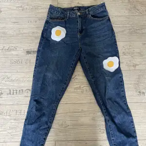 Blå jeans i mom-fit. Märken liknande stekta ägg på dem. Använda 1/2 gånger. Säljer på grund av att det inte är min stil.