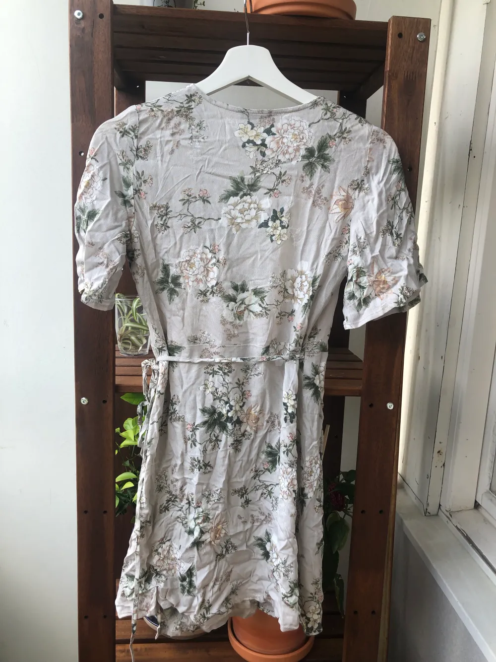 Somrig kort wrapklänning i ett grått blommigt mönster. Köpt för några år sedan men knappt använd så är i jättebra skick. . Klänningar.