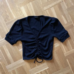 Topp - Svart topp m knytning från Trendyol. Inköpt på secondhand, använd men fint skick. Något nopprig. Storlek S men passar även M, mjuk och stretchig. 