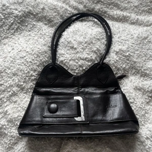 Vintage handväska - Med sorg i hjärtat säljer jag nu denna handväska då jag håller på att rensa garderoben. Passar perfekt som skol/vardags-väska, har flera fack och är antagligen i äkta läder. Färgen är brun-svart i verkligheten.