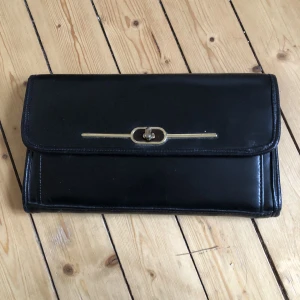 Kuvert/aftonväska i äkta läder - Något större kuvertväska i äkta läder. Tre stora fack, 2 fickor med blixtlås och två mindre fickor.   Ca 30cm bred. Två små skavanker på undersidan (se bild 3). Utan axelrem. 