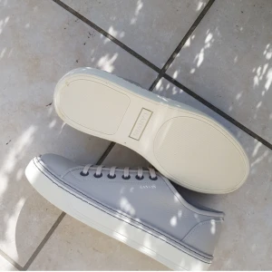 Lanvin skor - Sjukt snygga och stilrena ”Lanvin basket cuir” i färgen vit/grå. Storlek 42 men passar även 43. Köpta på Vestiaire Collective.  Tar även emot byten emot andra lanvins på dessa!