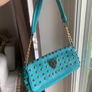 Väska - Säljer denna super fina turkosa väska som jag köpte secondhand för några år sedan. Nästan aldrig använd. Två band tillkommer ett längre som går att ta av. 