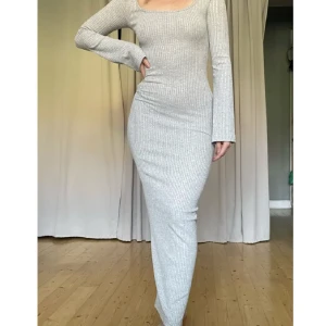 Grå långklänning  - Säljer den här klänningen ifrån Nelly som är i fint skick. Den är slutsåld. I storlek XS. Formar sig snyggt på kroppen, påminner om skims då den formar sig snyggt på kroppen, samt är ribbad.   