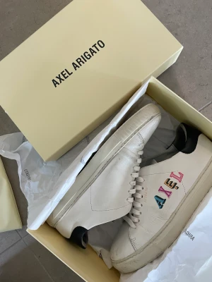 Axel arigato - Axel arigato skor, lite slitna  Nypris runt 2000 mitt pris 700kr. Originalbox samt dustbag medföljer 