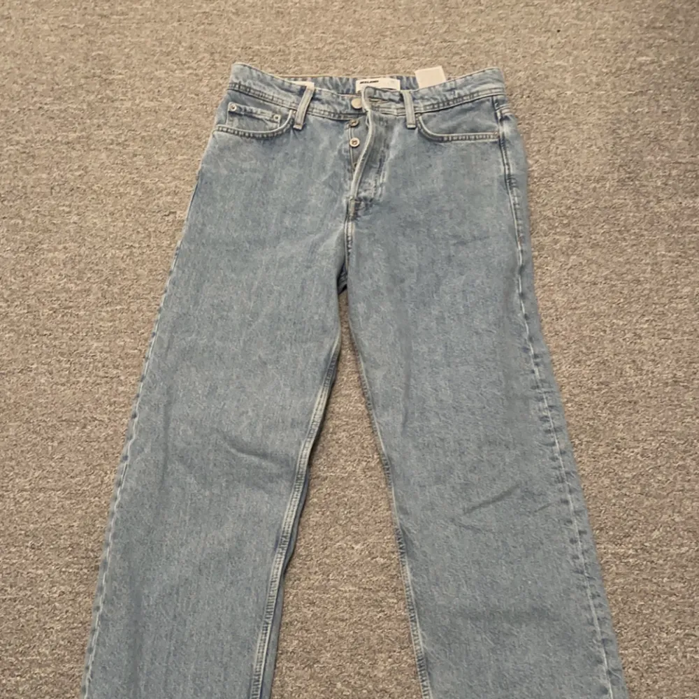Ett par vida ljusblåa Jack & Jones jeans som aldrig har kommit till användning trots att de är väldigt snygga och populära. Skick 10/10 Hör av er vid funderingar!. Jeans & Byxor.