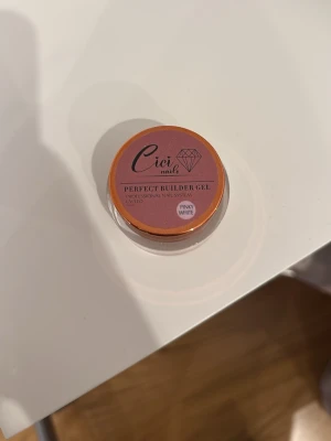 Cici Nails Perfect Builder Gel Pinky White - Byggel från Cici Nails i färgen Pinky White. Gelen kommer i en rund burk med skruvlock och har en mjuk rosa ton som passar perfekt för naturliga naglar eller fransk manikyr. Perfekt för dig som vill bygga eller förstärka naglar med en professionell finish.