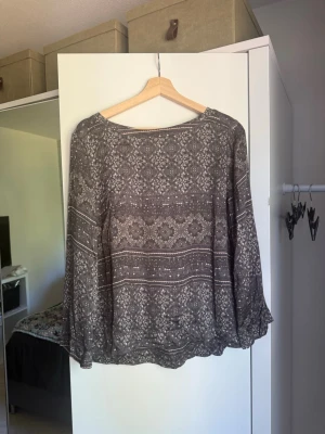 Grå blus med vitt mönster - Säljer en luftig grå blus med vitt blommigt och geometriskt mönster. Blusen har långa, vida ärmar och rund halsringning. Perfekt till både vardag och fest! Skön och sval att bära. Köp direkt eller skicka ett bud. Från märket Odd Molly i storlek 3 som enligt deras storlekguide motsvarar en storlek L. Mycket fint skick, tyvärr finns tråddragning. 