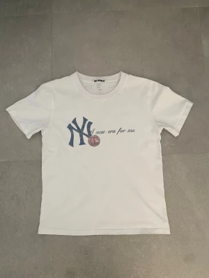 2K WRLD T-shirt - Säljer denna goa 2K WRLD T-shirt som ej säljs längre med yankees tryck och texten ”a new era for me” där av priset, liten i storlek så skulle säga att den är mer mot en XS, hör av dig vid några funderingar