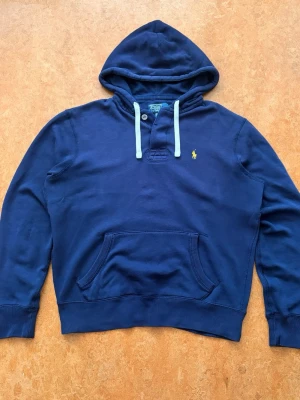 Marinblå hoodie från Polo Ralph Lauren - I princip nyskick trots åldern. Unik stil med knappar. Storlek M/M 