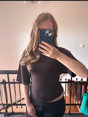 Brun tröja - Säljer en brun t-shirt som går in vid sidan och formar och lösare i armarna.  och rund hals. T-shirten har korta ärmar och är tillverkad i mjuk bomull. Perfekt för en avslappnad och enkel stil. Helt ny!