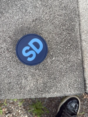 Blå snusdosa med SD-logga - Mörkblå snusdosa i plast med ljusblå SD-logga på locket och texten 'Sverigedemokraterna' på sidan. Praktisk förvaring för snus, enkel att ta med sig i fickan eller väskan.