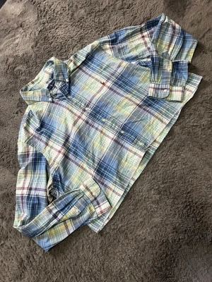Ralph Lauren Oversized Crop Top Skjorta - cropped skjorta från Ralph Lauren i schysst oversized modell. Snygga pastel/blå rutor med klassisk broderad logga. Perfekt streetstyle-look!