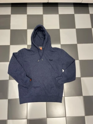 Superdry Hoodie  - En stilren mörkblå Superdry hoodie i storlek S. Otroligt skön hoodie och sitter som slim fit. Hoodien är välbehandlad och har inga skador eller tecken på användning 