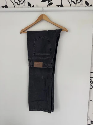 Svarta raka jeans just junkies - Säljer ett par svarta jeans med rak passform. Jeansen har en läderpatch bak i midjan och är tillverkade i denim. Perfekta för dig som gillar en enkel och stilren look. Nypris ca 800:-